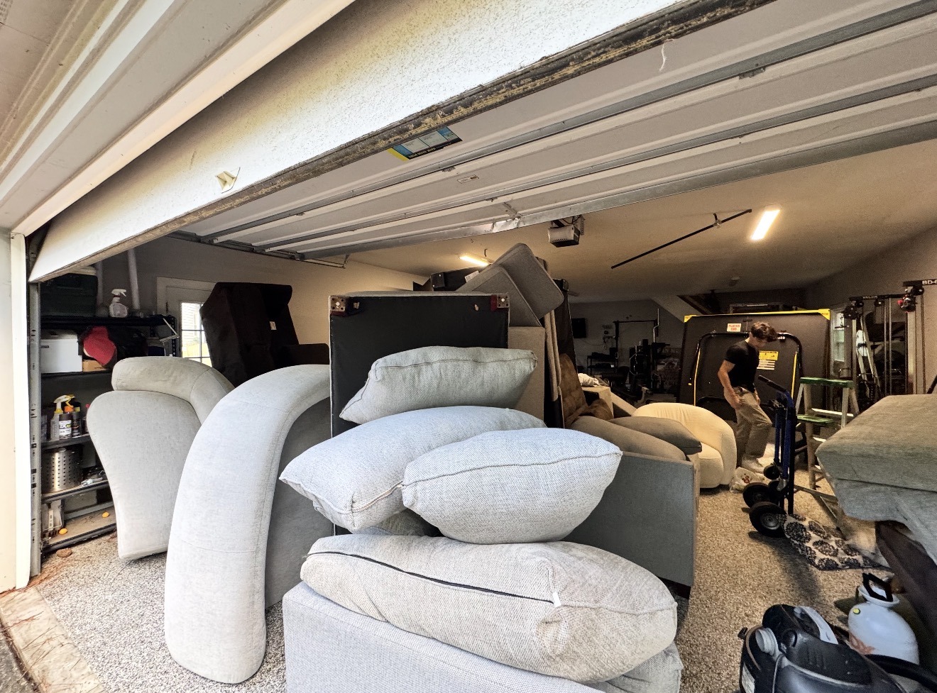 Julian working among couch cushions in his parents' crowded garage